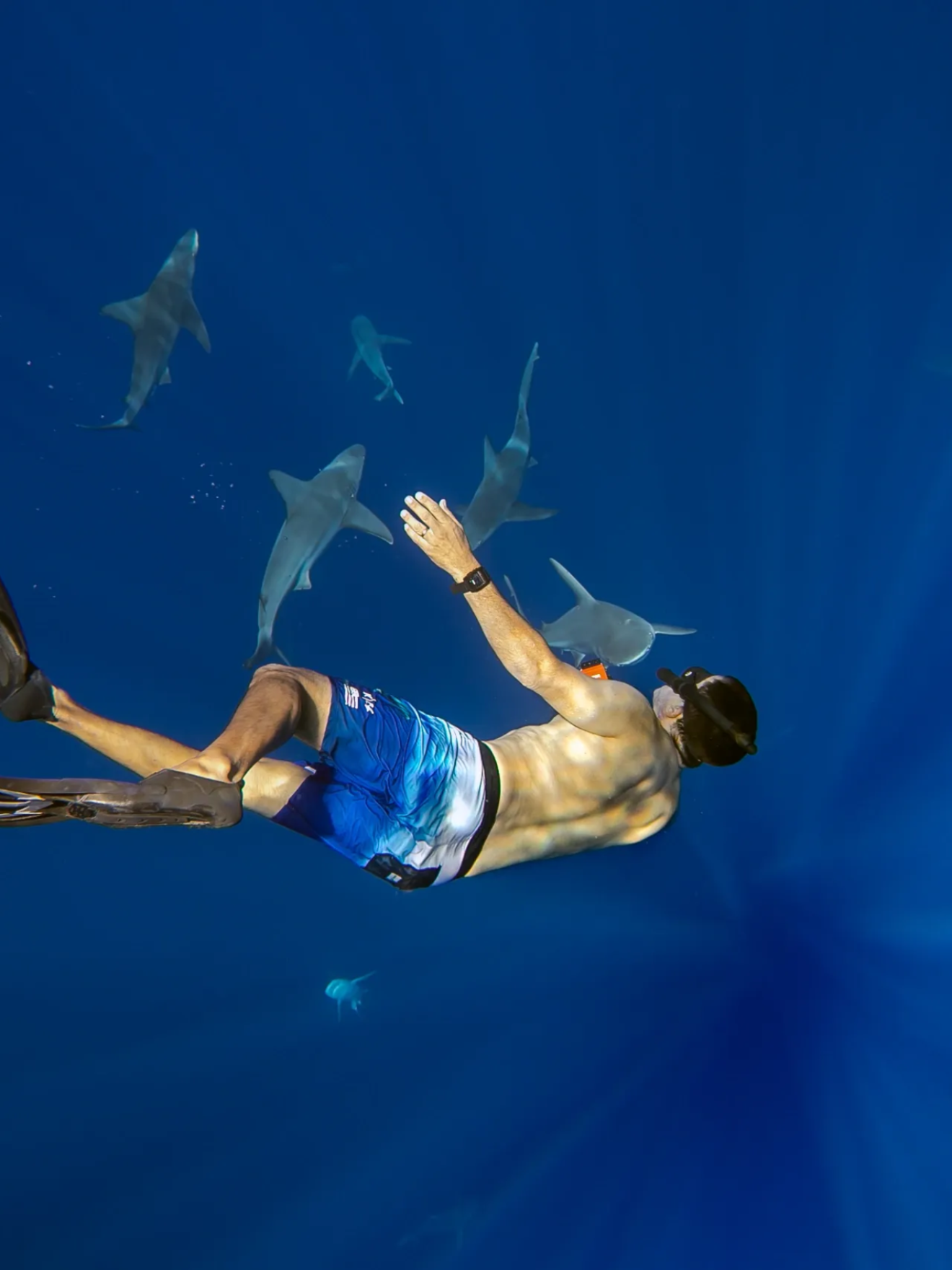 a man flying through the air while swimming in blue water